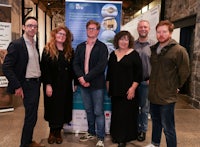 a group of people standing in front of a banner